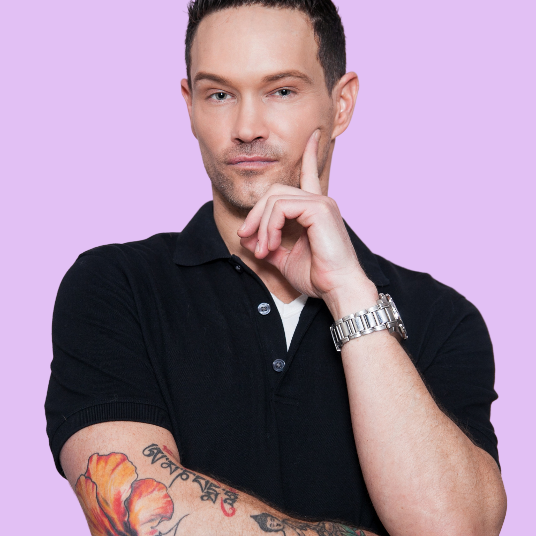 Man in black polo shirt with tattoos on arm, wearing a watch, against a light gray background